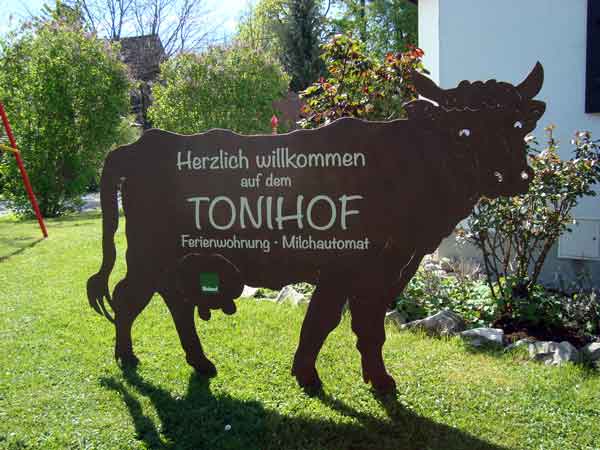 Eine Tafel in Form einer Kuh mit der Aufschrift "Willkommen auf dem Tonihof"